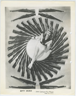 Grable, Betty. (1916 - 1973) Vintage 1942 WWII Pinup surrounded by Rifles!